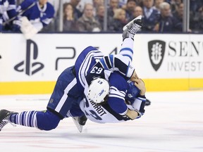 Toronto Maple Leafs centre Daniel Winnik (26) takes down Winnipeg Jets defenseman Ben Chiarot (63) as they fight at Air Canada Centre Saturday night. Chiarot was injured in the fight and will miss about six weeks.