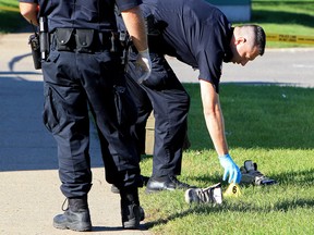 Police officers gather evidence near 1411 Millwoods Road East, following an early morning suspicious death, Monday Aug. 6, 2012. DAVID BLOOM EDMONTON SUN