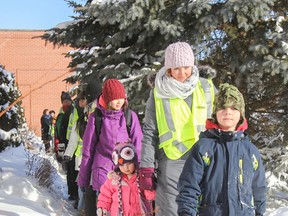Wesley MacLeod, right, Theresa MacLeod and Isobel MacLeod lead a group of students into James R. Henderson Public School as part of the school's Walking School Bus program. The program runs four mornings a week and gives students the chance to get some exercise along with help with traffic congestion problems at the school in the mornings. (Julia McKay/The Whig-Standard)