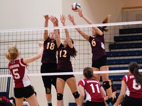 A trio of Regiopolis-Notre Dame Panthers players try to block the ball during the Kingston Area senior girls volleyball championship match at Queen's University's Athletics and Recreation Centre Monday night. The Panthers swept the match 3-0. (Julien Gignac/For The Whig-Standard)
