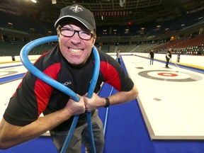 Volunteer Lee Smith helps out as they flood the ice at the Scotiabank Saddledome for the Tim Hortons Brier in Calgary, Alta. on Monday February 23 2015. Darren Makowichuk/Calgary Sun/QMI Agency