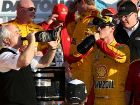 Team owner Roger Penske and his driver Joey Logano chug down some champagne after winning the Daytona 500 on Sunday. (Chris Graythen/Getty Images)