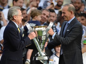 MLS commissioner Don Garber (right) presents Los Angeles Galaxy owner Philip Anschutz with the MLS Cup championship trophy. (USA TODAY SPORTS)