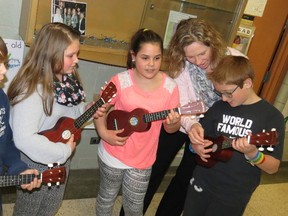 Fitch Street School students play new ukuleles donated to the Welland school by superstar country band Lady Antebellum. From left are Myles Chew, Hope Campbell, Malaya Morales and Andrew Comfort with teacher Susanne Anderson. (GREG FURMINGER/Tribune Staff)