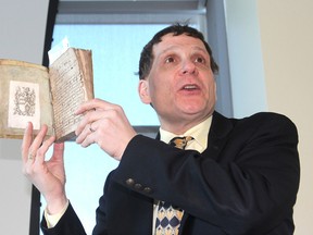 Queen's University principal Daniel Woolf uses a rare book from his own collection to illustrate a point on censorship during an event on campus for Freedom To Read Week, which recognizes the challenges to controversial books. (Michael Lea/The Whig-Standard)