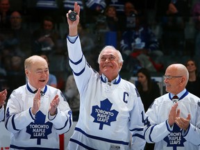 Former Maple Leafs captain and Coniston native George Armstrong waves to the crowd in between Red Kelly (L) and David Keon during a ceremony commemorating the 50th anniversary of the Leafs 1964 Stanley Cup victory before action between the Toronto Maple Leafs and the Vancouver Canucks at the Air Canada Centre on Feb. 8, 2014 in Toronto. Armstrong is joining Legends Row with a monument outside the Air Canada Centre this Saturday.