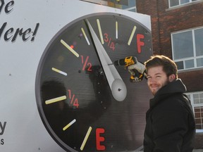 Taylor McBain, of McBain Signs and Graphic Design in Sparta, adjusts Elgin-St. Thomas United Way’s campaign thermometer in this file photo.  (Contributed)