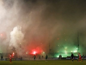 Smoke from flares lit by Panathinaikos' fans rises during the Greek Super League soccer match between Panathinaikos and Olympiakos at Leoforos stadium in Athens February 22, 2015. REUTERS/Kostas Tsironis