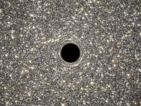 A handout photo released on Sept. 18, 2014, by ESA/Hubble shows an illustration of the supermassive black hole located in the middle of the very dense galaxy M60-UCD1. (AFP FILE PHOTO/NASA/ESA/HUBBLE/D. Coe, G. Bacon (STScI))