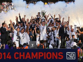 Captain Robbie Keane of the Los Angeles Galaxy hoists the Philip F. Anschutz Trophy as his teammates cheer on following  the 2014 MLS Cup at StubHub Center on December 7, 2014 in Los Angeles. (Victor Decolongon/Getty Images/AFP)