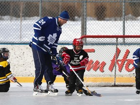 Toronto Maple Leafs player Peter Holland plays keep away with a group of little hockey players at Trinity-Bellwoods arena in Toronto Feb. 24, 2015. (Jack Boland/Toronto Sun)