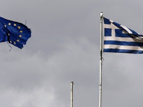 Frayed EU and Greek flags flutter atop the Greek Ministry of Finance in central Athens February 24, 2015. 
REUTERS/Yannis Behrakis