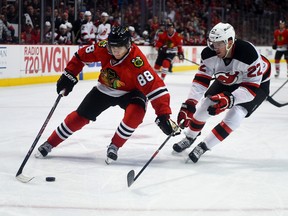 Chicago Blackhawks winger Patrick Kane (88) tries to get around New Jersey Devils defenceman Eric Gelinas during NHL play at the United Center. (Mike DiNovo/USA TODAY Sports)