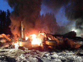 Heavy equipment is used in an attempt to extinguish a fire after a crude oil train derailment 80 km south of Timmins, Ontario. (REUTERS)