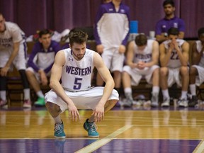 Tom Filgiano and the Western Mustangs bench react as the final buzzer signals the end of their season after the Laurier Golden Hawks beat them 90-82 in an OUA quarterfinal at Alumni Hall on Wednesday. (DEREK RUTTAN, The London Free Press)