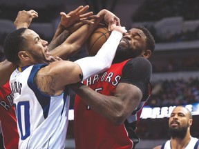 Raptors forward Amir Johnson and Mavericks guard Devin Harris fight for a rebound on Wednesday in Dallas. (USA TODAY SPORTS)