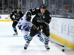 Raffi Torres #13 of the San Jose Sharks skates with the puck ahead of Alex Burrows #14 of the Vancouver Canucks in Game Three of the Western Conference Quarterfinals during the 2013 NHL Stanley Cup Playoffs at HP Pavilion on May 5, 2013 in San Jose, California. The Sharks defeated the Canucks 5-2.  Christian Petersen/Getty Images/AFP