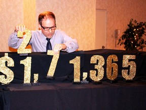 Campaign co-chair Dan Henry adjusts the digits in the 2014 United Way Oxford campaign total to reveal the record-breaking achievement of $1,175,236. (Megan Stacey, Sentinel-Review​)