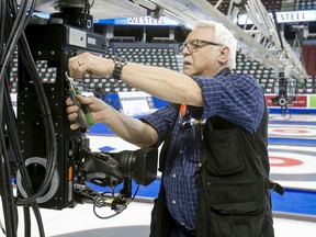 Len Dubyts, an overhead robotics camera operator with TSN, makes some adjustments to a sliding camera before the start of the Brier Thursday at the Scotiabank Saddledome in Calgary. (Lyle Aspinall, QMI Agency)