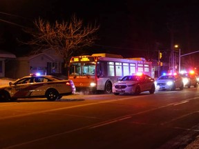 Ottawa Police and OC Transpo security surround a bus along Smythe Rd. Thursday night. A window was smashed by some sort of object, but luckily no one was injured. (JP Thibault submitted image)