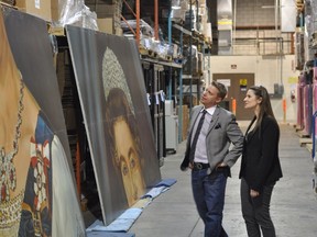New owner Jamie Boychuk and local artist Amanda Von Riesen, who helped set up the deal, check out the 1979 portrait of Queen Elizabeth II for the first time Friday, Feb. 27, 2015. Boychuk bought the painting and is bring it back to Winnipeg.