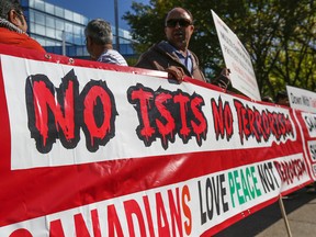 Demonstrators hold up signs at an anti-ISIS rally at City Hall in Calgary on Sept. 13, 2014. (Gavin John/QMI Agency)