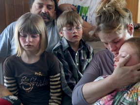 Eric Courtney, his wife Teenah Snowden and their kids sit in shock in their Gracefield, Que. home, Feb 27, 2015. The Courtney family lost two kids in a house fire Thursday night. (Tony Caldwell/QMI Agency)