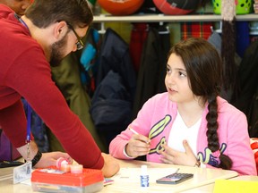 Student teacher Mathieu Robichaud talks to Maryam, a Grade 6 student at Saint Charles Garnier Catholic School in Toronto on Feb. 17, 2015. (Michael Peake/Toronto Sun)
