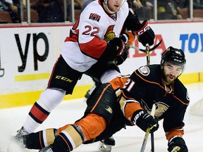 Feb 25, 2015; Anaheim, CA, USA; Anaheim Ducks right wing Kyle Palmieri (21) falls as he attempts to move the puck defended by Ottawa Senators right wing Erik Condra (22) during the first period at Honda Center. Mandatory Credit: Kelvin Kuo-USA TODAY Sports