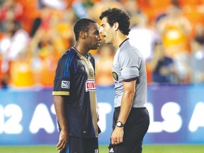 MLS referee Fotis Bazakos (right) talks with Philadelphia’s Amobi Okugo after a penalty call. (Getty Images/AFP)