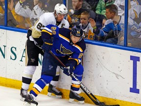 Feb 21, 2015; St. Louis, MO, USA; St. Louis Blues center Paul Stastny (26) and Pittsburgh Penguins center Sidney Crosby (87) fight for the puck in the corner during the third period at Scottrade Center. The Penguins defeated the Blues 4-2. Mandatory Credit: Billy Hurst-USA TODAY