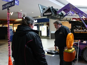 Paul Renaud, sales manager with A&A Asphalt, speaks with potential client Sivia Gold at the Kingston Home Builders Association's Home&renovation Show at the Cataraqui Centre in Kingston, Ont. on Sunday March 1, 2015.Steph Crosier/Kingston Whig-Standard/QMI Agency