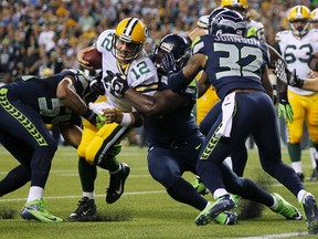 Green Bay Packers quarterback Aaron Rodgers (12) is tackled three yards from the endzone by Seattle Seahawks Bobby Wagner (54), Clinton McDonald (69) and Jeron Johnson (32) during the fourth quarter of their Monday night NFL football game at Centurylink Field in Seattle, Washington, September 24, 2012.  (REUTERS)