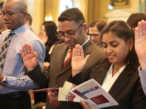 Jose and Limy Tharayil recite the oath of citizenship  Jan. 9, 2015 at a citizenship ceremony in Kingston, Ont. (ELLIOT FERGUSON/QMI Agency)