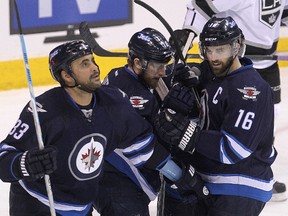 Winnipeg Jets left winger Andrew Ladd (r) celebrates his first goal against the Los Angeles Kings with teammates Dustin Byfuglien (l) and Bryan Little during NHL hockey in Winnipeg, Man. Sunday, March 01, 2015.
Brian Donogh/Winnipeg Sun/QMI Agency