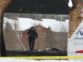 Sunday, March 1, 2015 Ottawa -- An Ottawa Fire investigator photographs all that remains of a $1 million-dollar home in the Manotick area Sunday, March 1, 2015. The fire started early Sunday at the unoccupied home where the owners had just started moving items in.
DOUG HEMPSTEAD/Ottawa Sun/QMI AGENCY