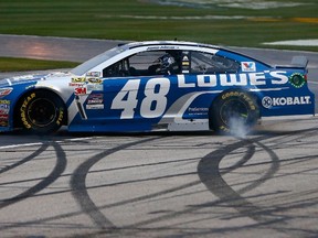 Jimmie Johnson, driver of the No. 48 Lowe’s Chevrolet, celebrates with a burnout after winning the NASCAR Sprint Cup Series Folds of Honor QuikTrip 500 at Atlanta Motor Speedway in Hampton, Ga., yesterday. (AFP)