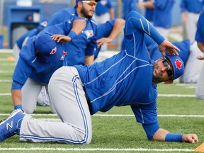 Jose Bautista gets in a stretch yesterday in camp. (Stan Behal/Toronto Sun)