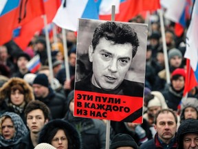 A portrait of Kremlin critic Boris Nemtsov, who was shot dead on Friday night, is seen during a march to commemorate him in central Moscow March 1, 2015. Holding placards declaring "I am not afraid", thousands of Russians marched in Moscow on Sunday in memory of Nemtsov, whose murder has widened a split in society that some say could threaten Russia's future. The words under the portrait reads "These bullets are meant for each of us". REUTERS/Maxim Shemetov