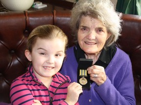 Christine Nichols, nee Essex, with her youngest granddaughter, 7-year-old Mimi Nichols, both of England, hold the precious Korea War medal earned by her brother John Essex, who died in an Ontario Hydro accident in 1957.
