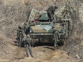 South Korean army soldiers disguise their armoured vehicle during a military exercise in Paju, near the demilitarized zone separating the two Koreas March 2, 2015. North Korea fired two short-range missiles off its east coast on Monday, South Korean officials said, a defiant response to annual military exercises between South Korea and the United States but one which drew a swift protest from Japan.  REUTERS/Lim Byung-sik/Yonhap