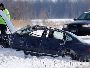 OPP investigate a rollover in the centre median on Hwy 416 in the south end of Ottawa on Monday, March 2, 2015. The driver of the car was taken to hospital after being ejected, and ending up in the oncoming traffic lanes. (TONY CALDWELL Ottawa Sun)