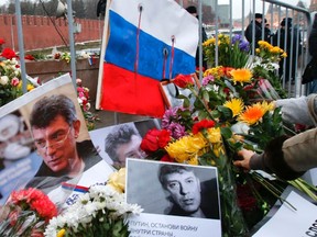 People lay down flowers at the site, where Kremlin critic Boris Nemtsov was murdered on Friday night, during a march to commemorate him in central Moscow March 1, 2015. Holding placards declaring "I am not afraid", thousands of Russians marched in Moscow on Sunday in memory of Nemtsov, whose murder has widened a split in society that some say could threaten Russia's future.    REUTERS/Tatyana Makeyeva
