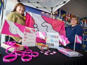 Betty Klodt, left, and Wendi Redman of The Flag Shop hold a flag featuring an anti-bullying design created by New Brunswick grade 7 pupil Grace Fenton at the Exeter Rd. store. (CRAIG GLOVER, The London Free Press)