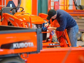 Sales representative Shawn Clancy polishes a tractor as he helps set up the Kubota booth at the 77th Farm Show at the Western Fair District Agriplex in London Monday. The show, which runs Wednesday through Friday, features more than 360 exhibitors and speakers, such as tweeting farmer Andrew Campbell. (CRAIG GLOVER, The London Free Press)