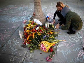 Students light candles at a tribute for victims, at one of nine crime scenes after a series of drive-by shootings that left 7 people dead, in the Isla Vista neighborhood of Santa Barbara, California May 26, 2014. Twenty-two year old Elliot Rodger killed six people before taking his own life in a rampage through a California college town shortly after he posted a threatening video railing against women, police said.  REUTERS/Lucy Nicholson/Files