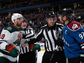 Linesmen Vaughan Rody #73 and Kiel Murchison #79 have to separate Nate Prosser #39 of the Minnesota Wild and Gabriel Landeskog #92 of the Colorado Avalanche at Pepsi Center on February 28, 2015 in Denver, Colorado. (Doug Pensinger/Getty Images/AFP)