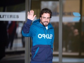 McLaren's Formula One driver Fernando Alonso of Spain gestures to the media as he leaves a hospital near Barcelona on Feb. 25, 2015. (Albert Gea/Reuters)