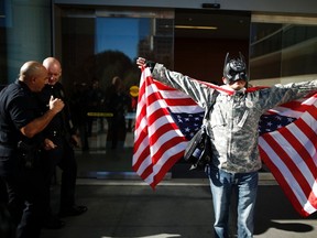 A man dressed as Batman protests against the killing of a homeless man by police outside LAPD headquarters in Los Angeles, California March 3, 2015. Los Angeles police officers trying to subdue a robbery suspect in the city's skid row section shot and killed the man as he tried to grab an officer's gun during a scuffle that was captured on video, police said on Monday. The dead man was reported by the Los Angeles Times to have been a homeless man known by his street name, Africa, who according to witnesses at the scene had been living in a tent for a few months after a period in a mental health facility. REUTERS/Lucy Nicholson (UNITED STATES - Tags: CRIME LAW CIVIL UNREST)