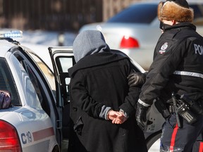 A woman is arrested after an incident at a house in the area of 112 Street and Saddleback Road, March 3, 2015. (IAN KUCERAK/EDMONTON SUN)